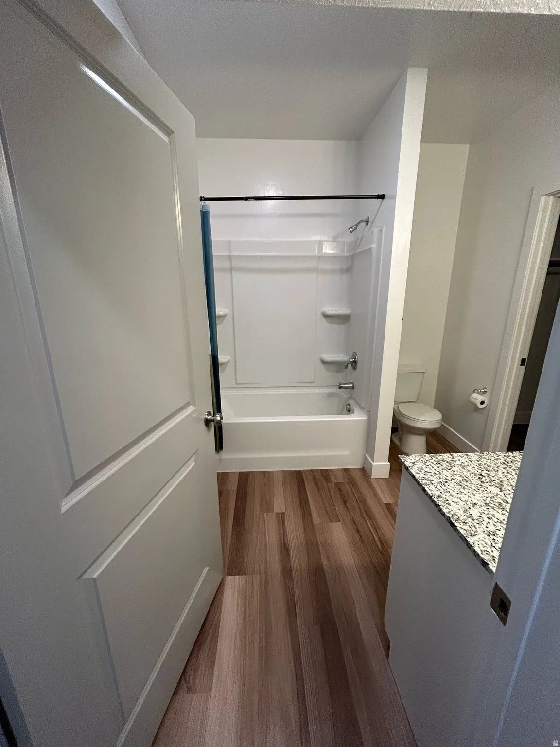 Full bath with shower / tub combination, vanity, and dark wood-type flooring