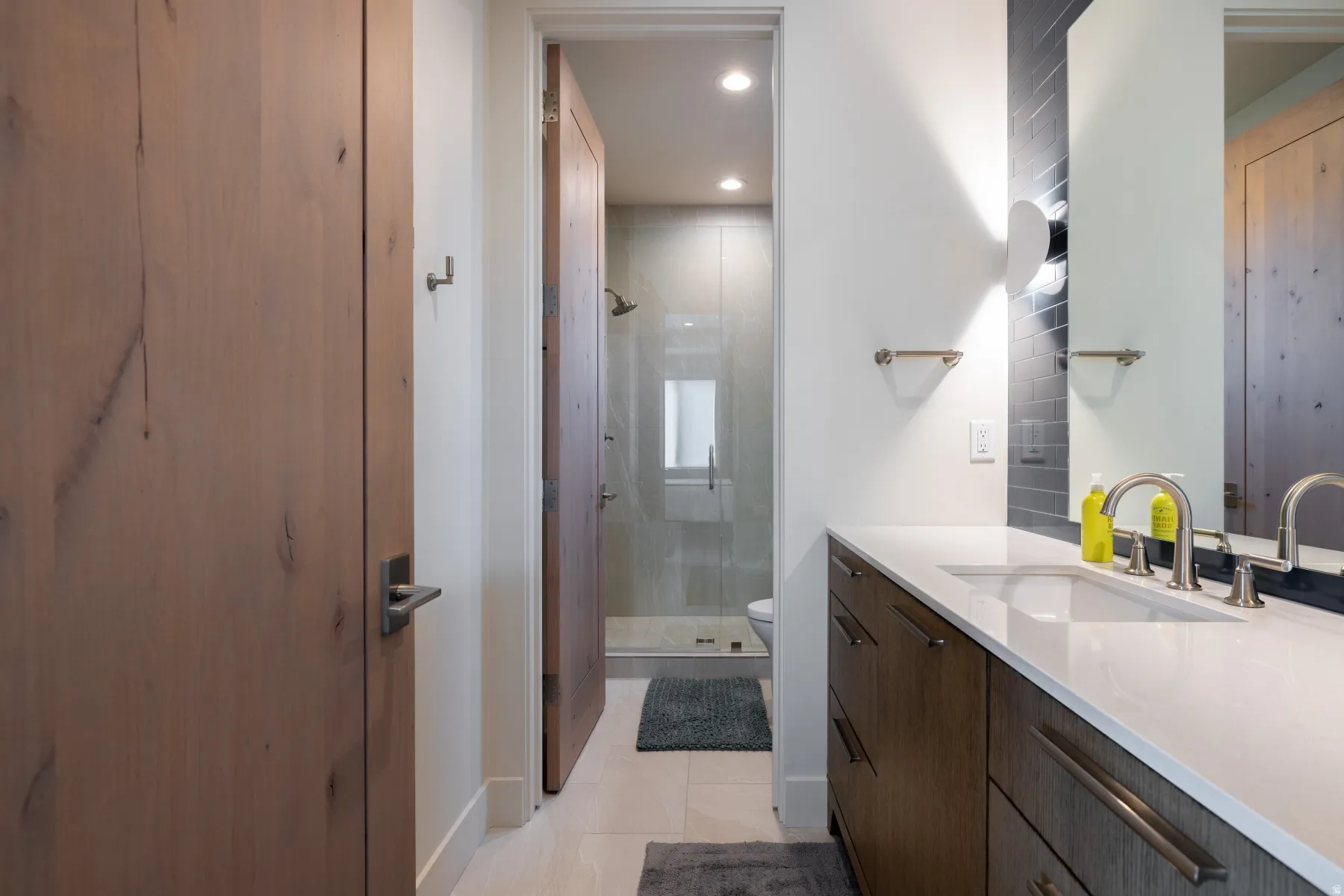 Bathroom with a shower stall, vanity, recessed lighting, and light tile patterned flooring