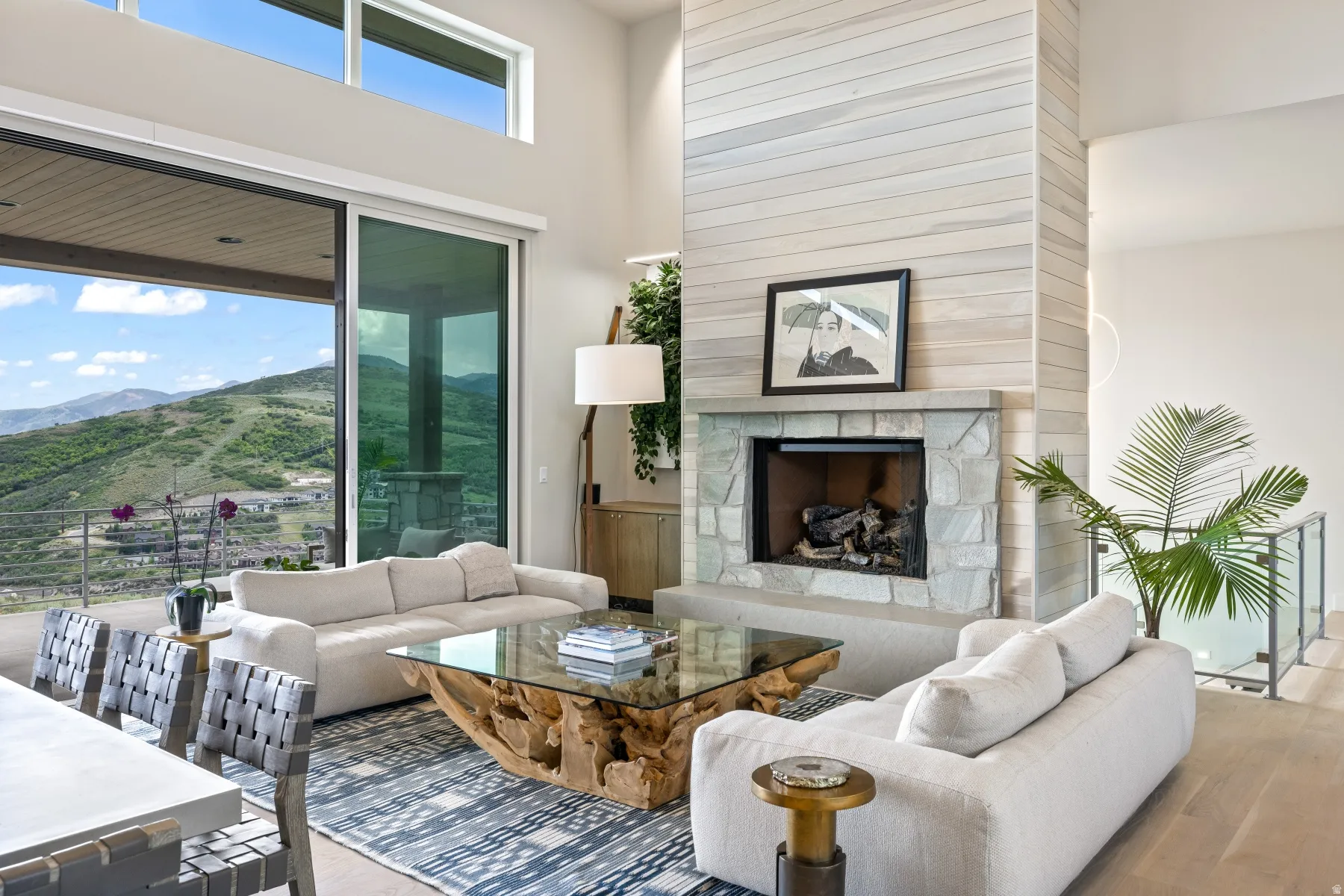 Living room with wood finished floors, a fireplace, a mountain view, healthy amount of natural light, and a towering ceiling