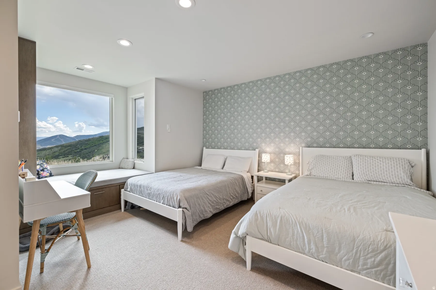 Bedroom featuring an accent wall, wallpapered walls, light carpet, recessed lighting, and a mountain view