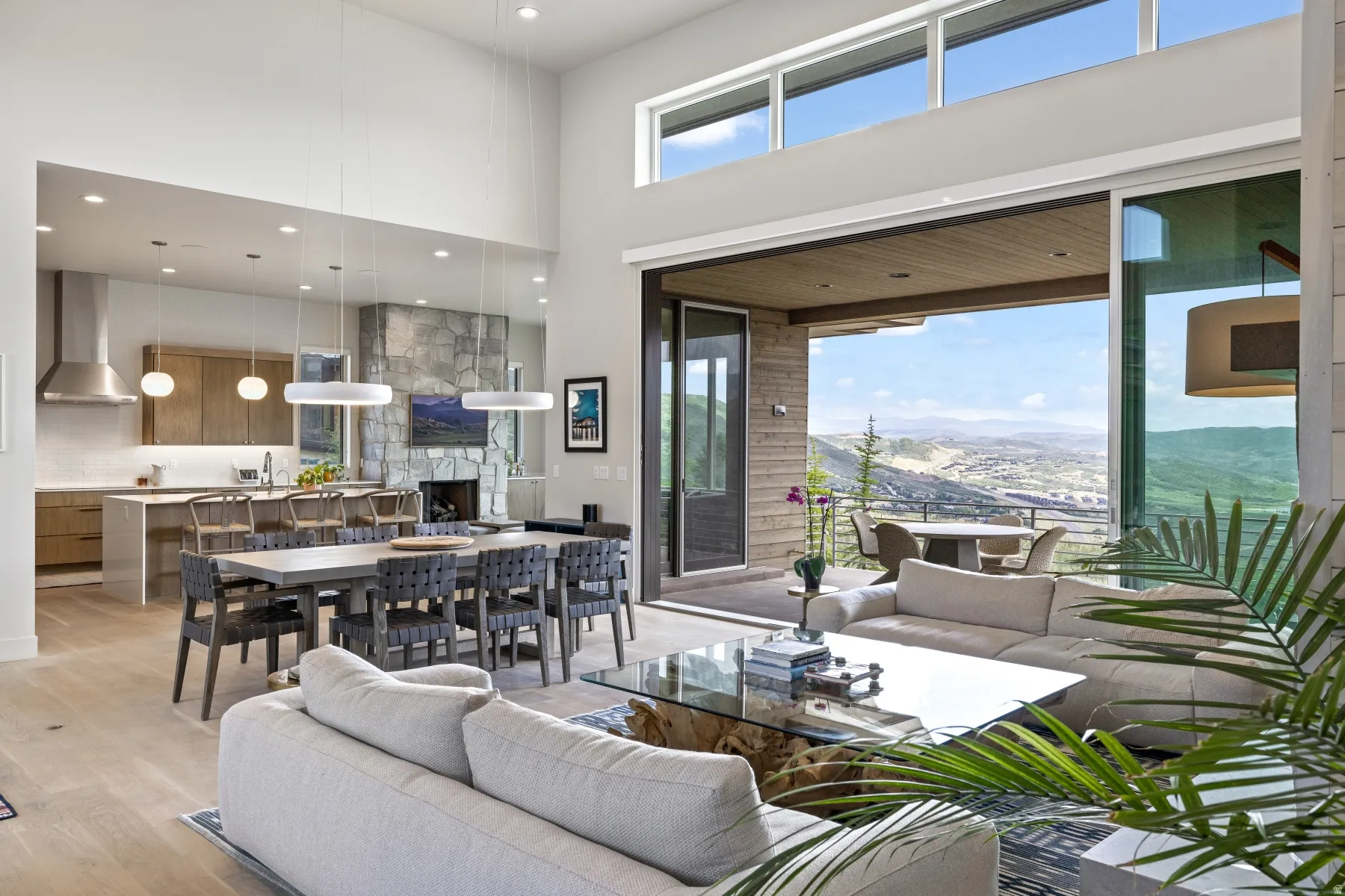 Living area with a high ceiling, light wood finished floors, recessed lighting, and a large fireplace