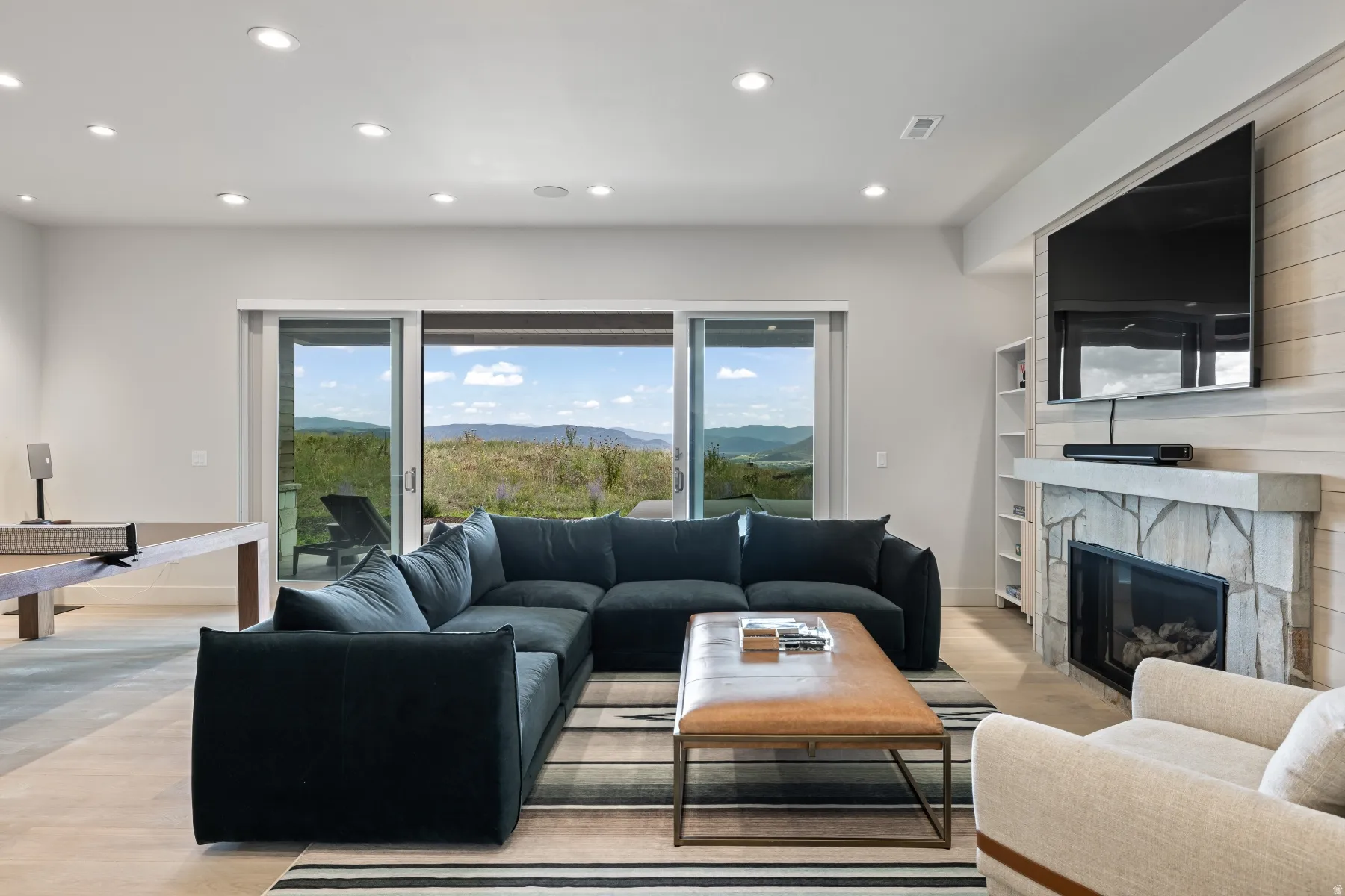 Living area featuring recessed lighting, light wood finished floors, and a large fireplace
