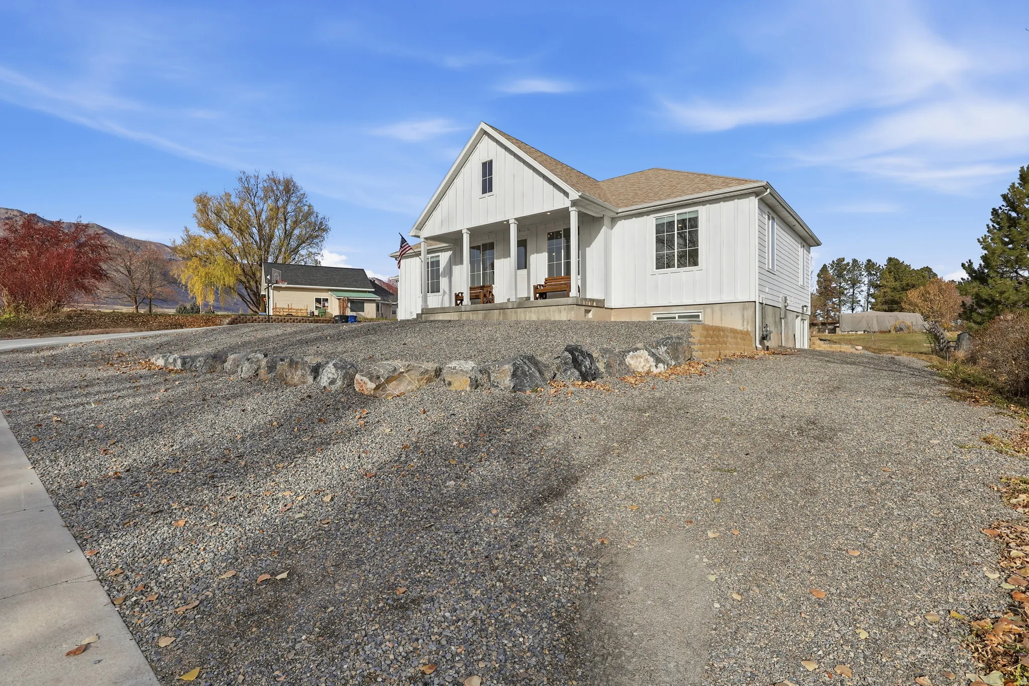 Modern farmhouse with a porch, a shingled roof, and board and batten siding