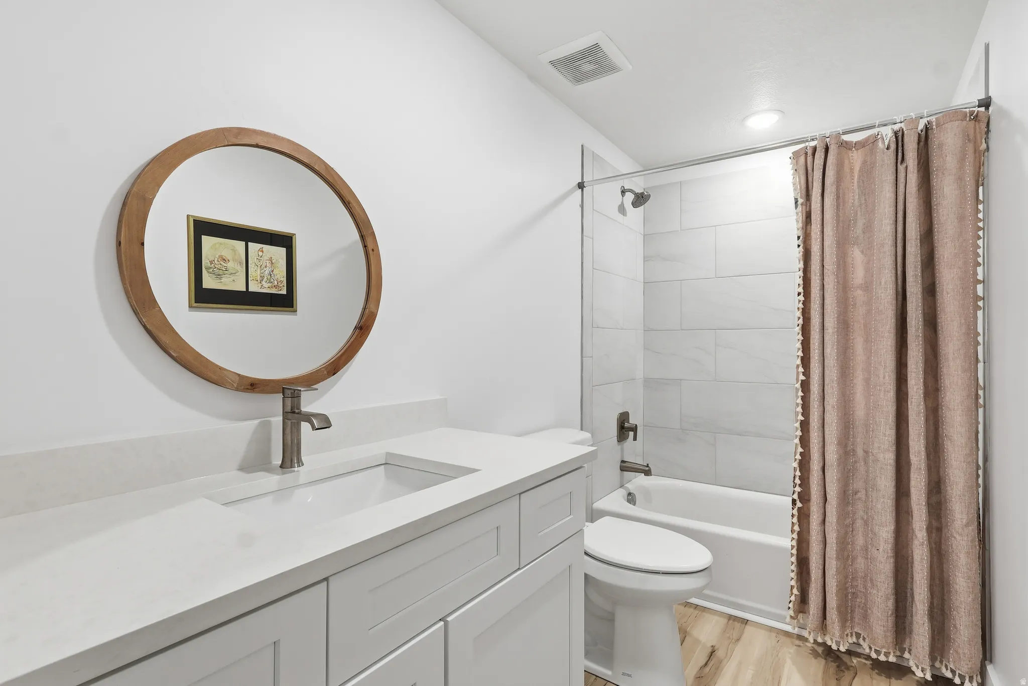 Full bathroom featuring shower / bath combo with shower curtain, vanity, and light wood finished floors
