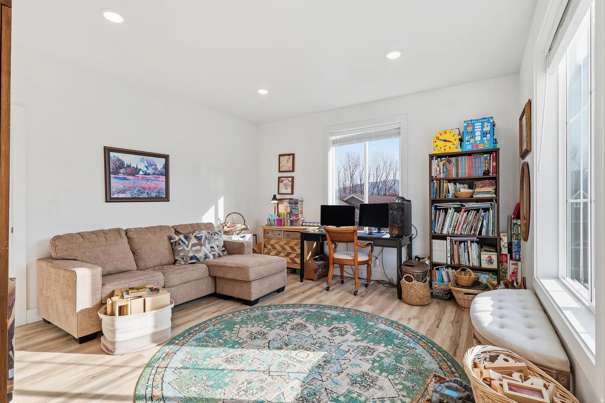 Living area featuring a desk, light wood-style floors, and recessed lighting