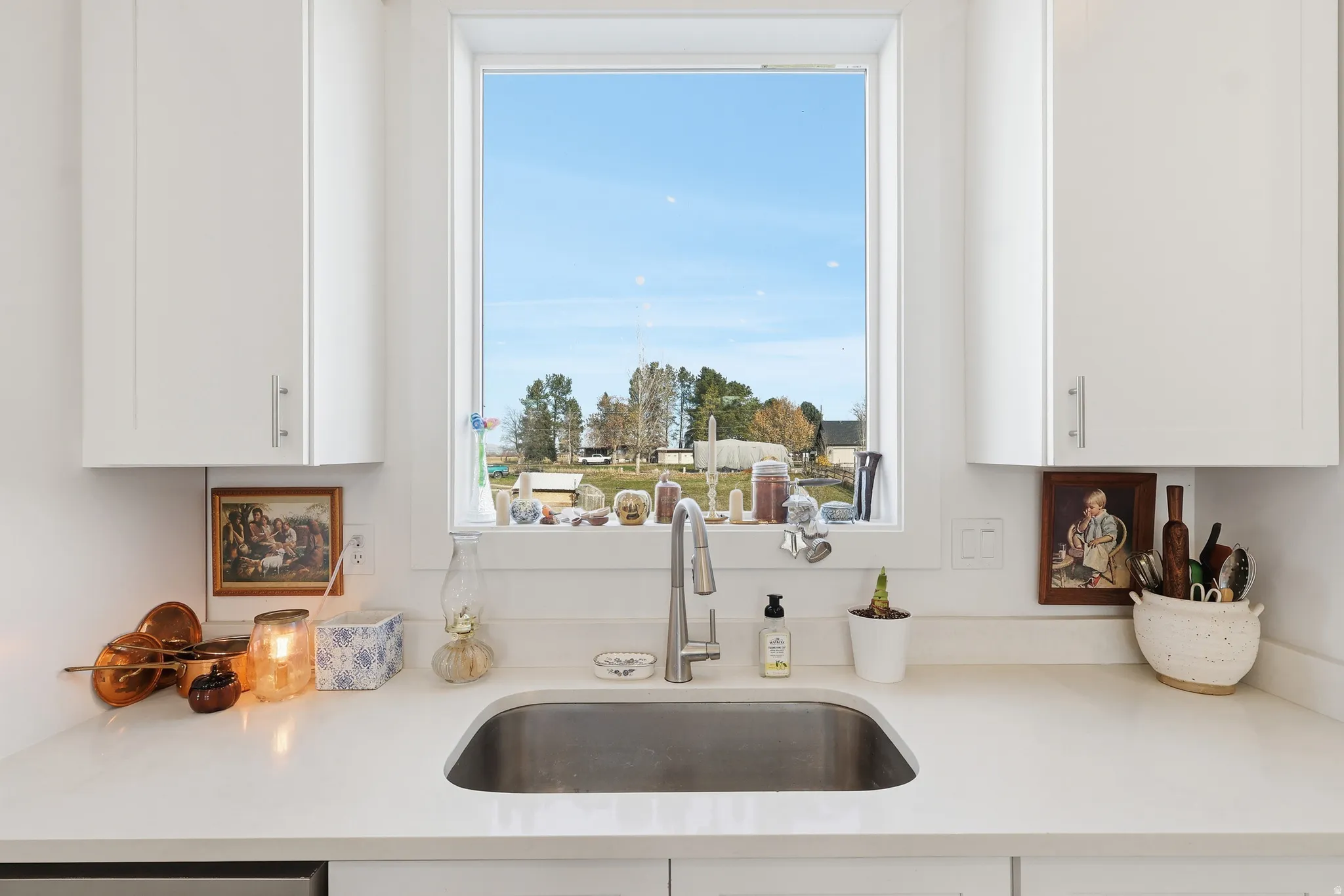 Kitchen featuring white cabinetry and light stone counters