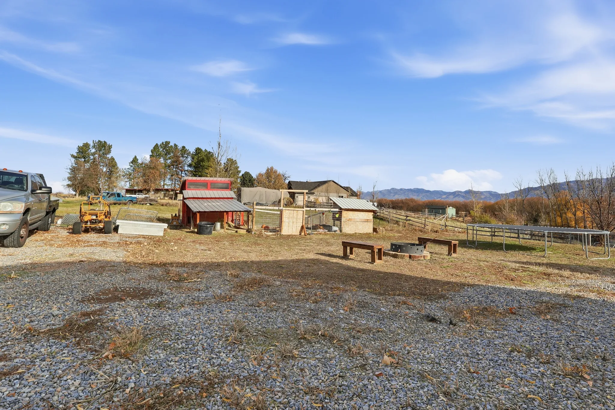 View of yard with a trampoline, an outbuilding, a view of countryside, and a mountain view