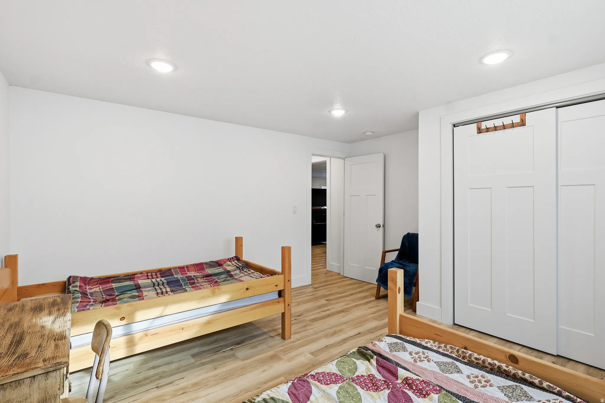 Bedroom with light wood finished floors, a closet, and recessed lighting