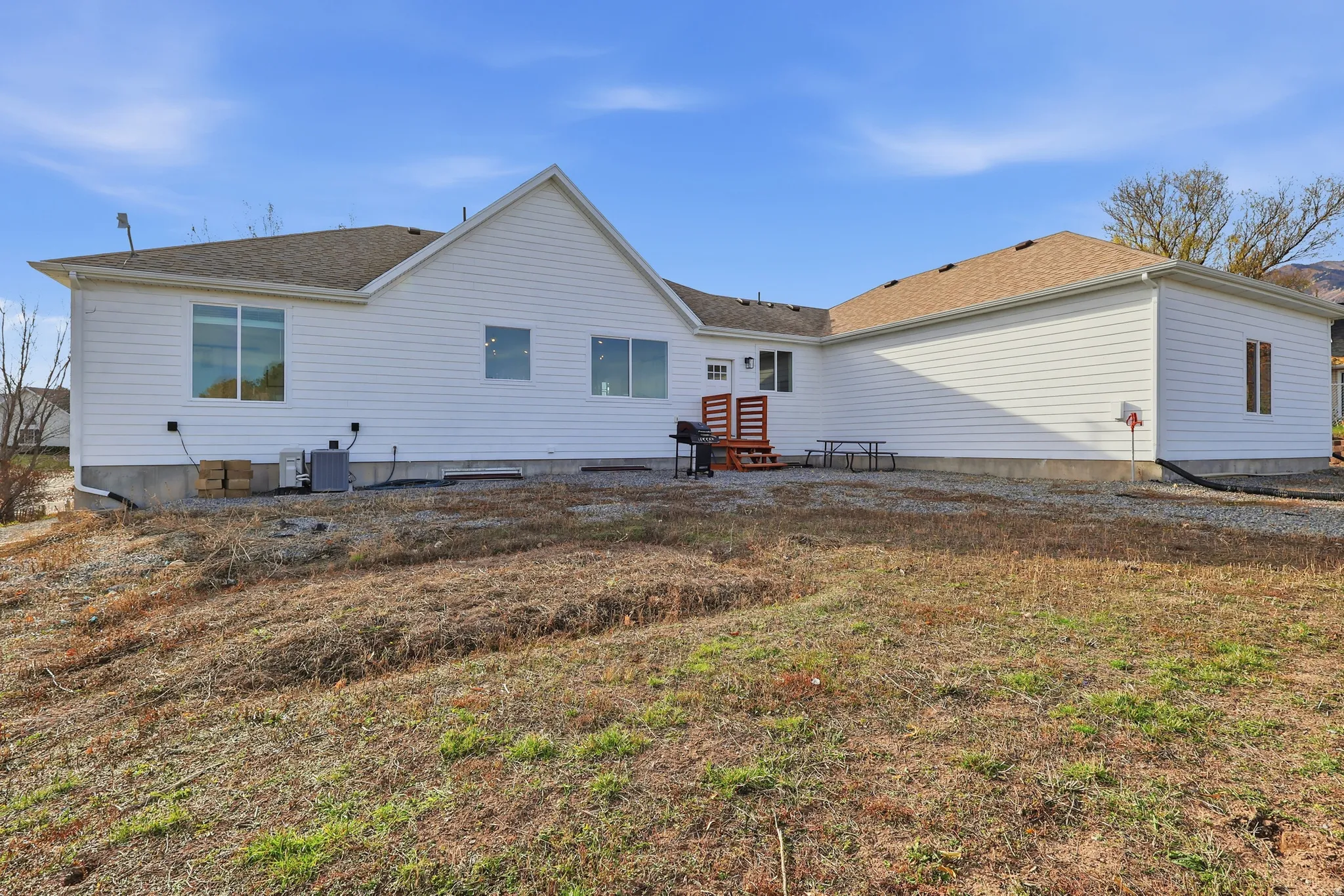 Back of house featuring a patio, a lawn, and a shingled roof