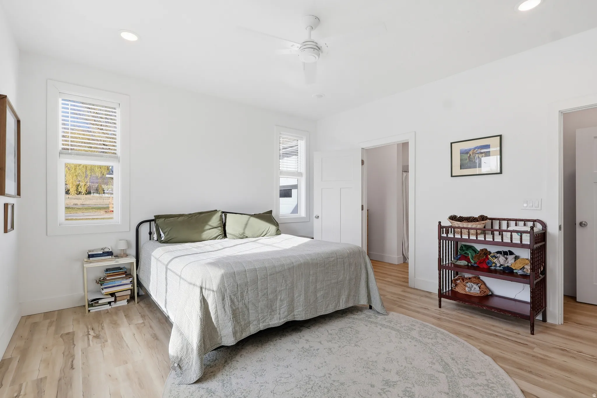 Bedroom with light wood finished floors, multiple windows, recessed lighting, and a ceiling fan