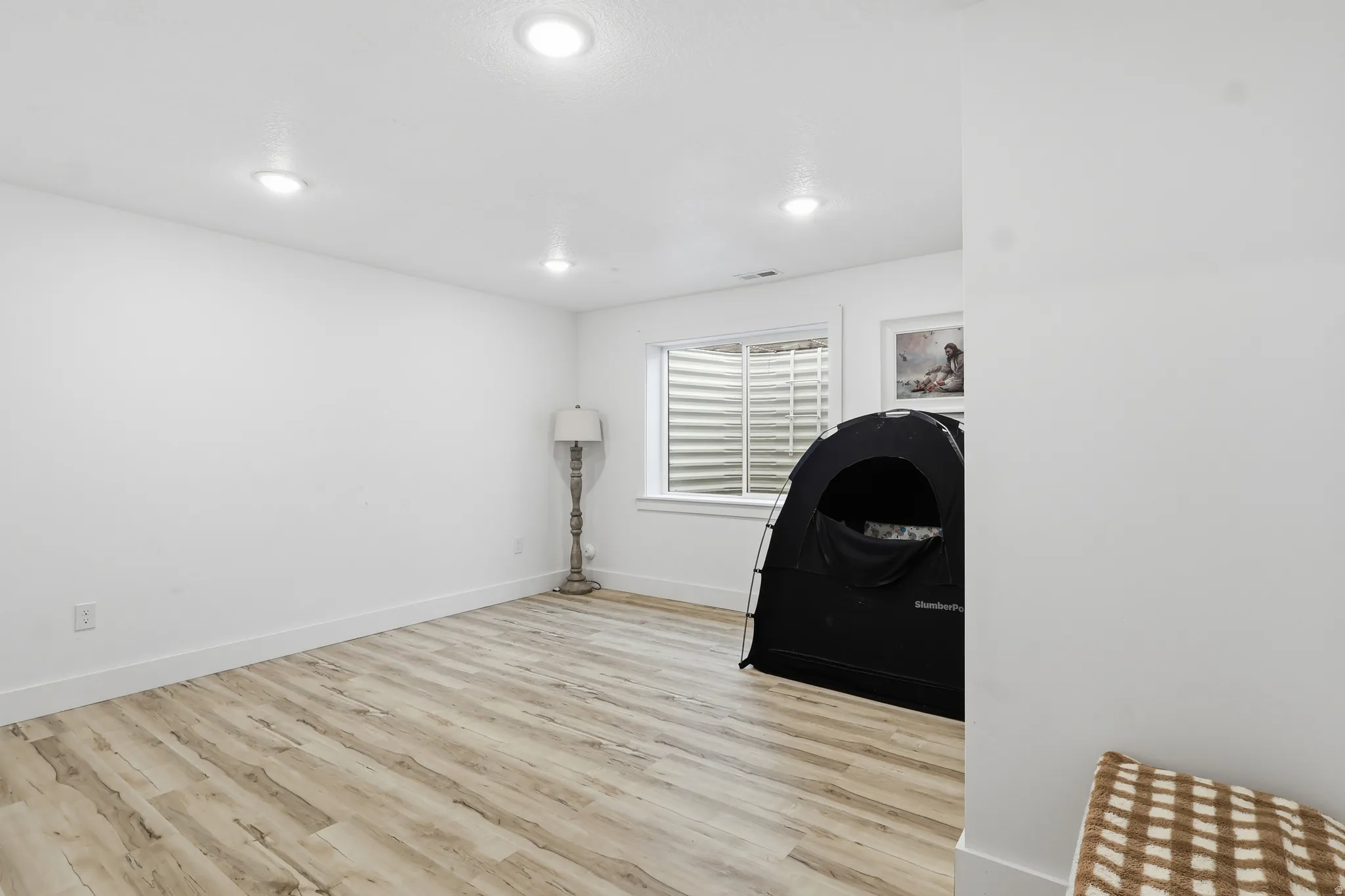 Exercise area featuring light wood-style flooring and recessed lighting