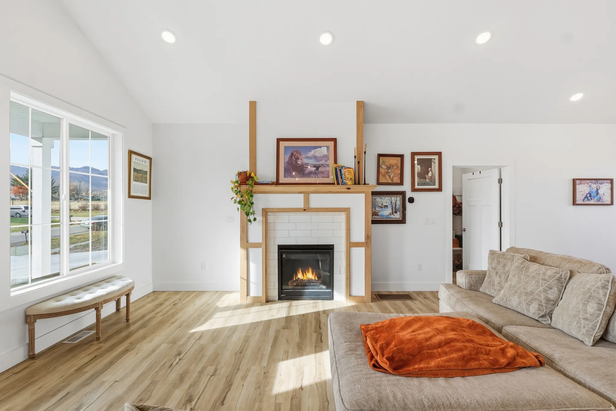 Living area featuring a fireplace, light wood finished floors, recessed lighting, and vaulted ceiling