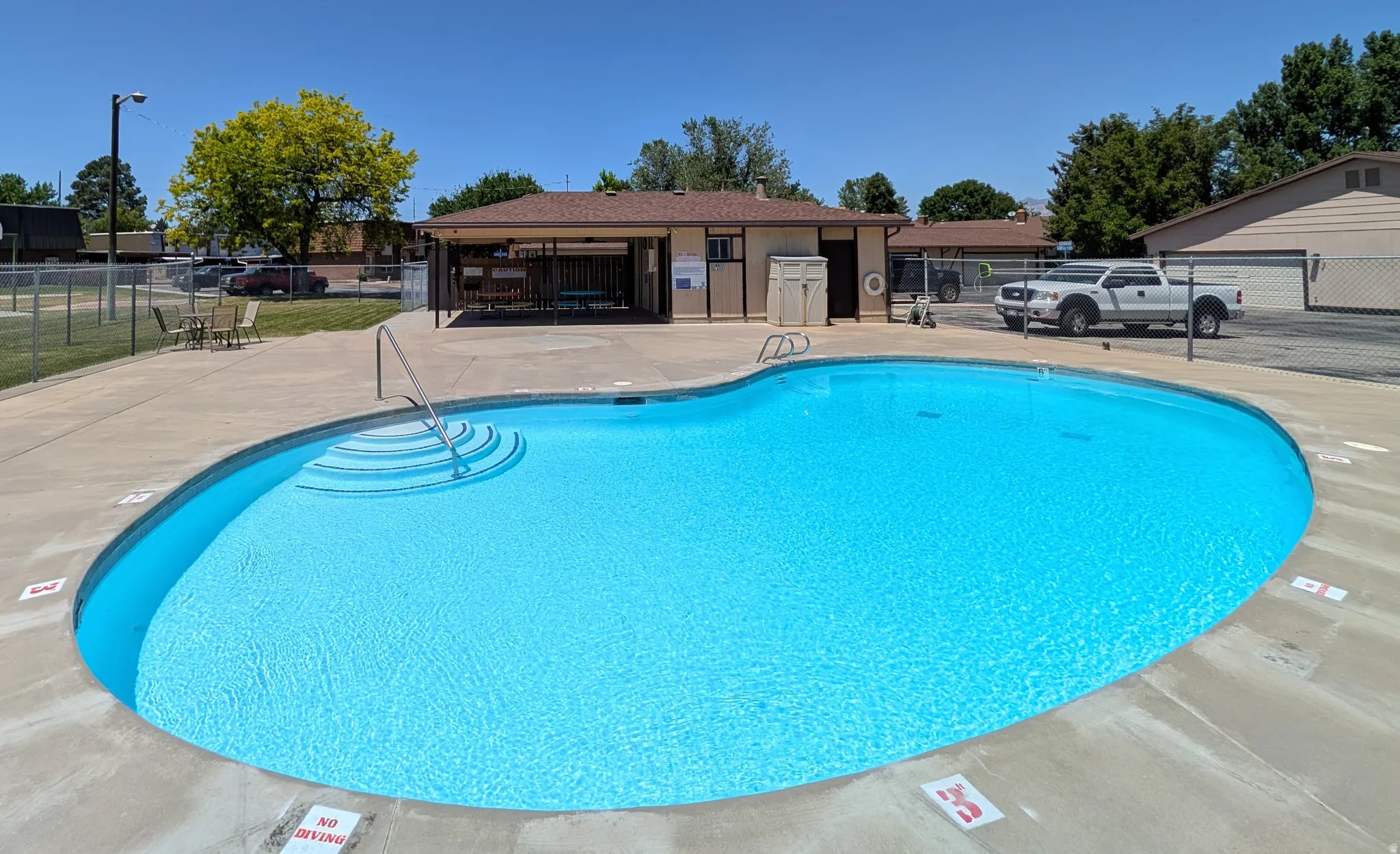 Community swimming pool with built-in steps and a concrete surround