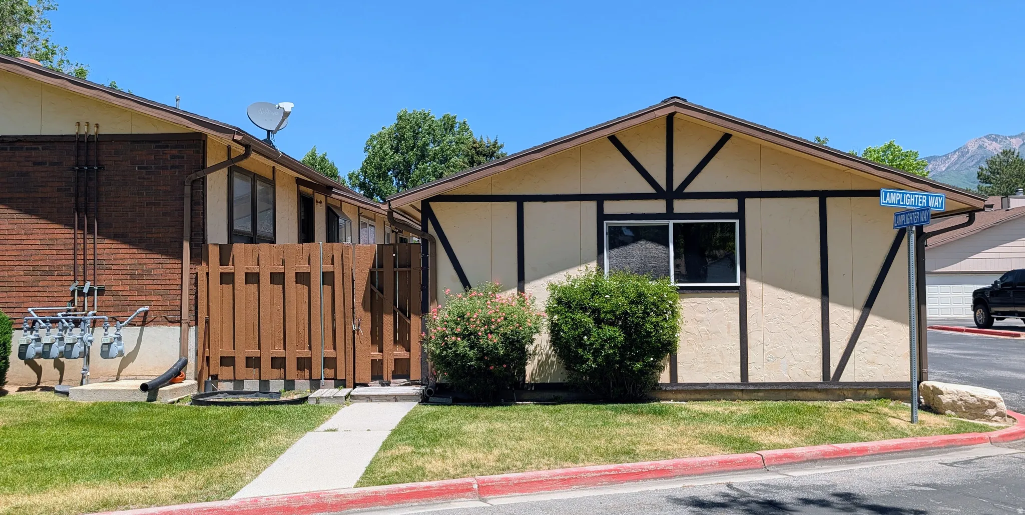 Exterior featuring a light-colored stucco finish with dark brown decorative trim and a dark brown window frame