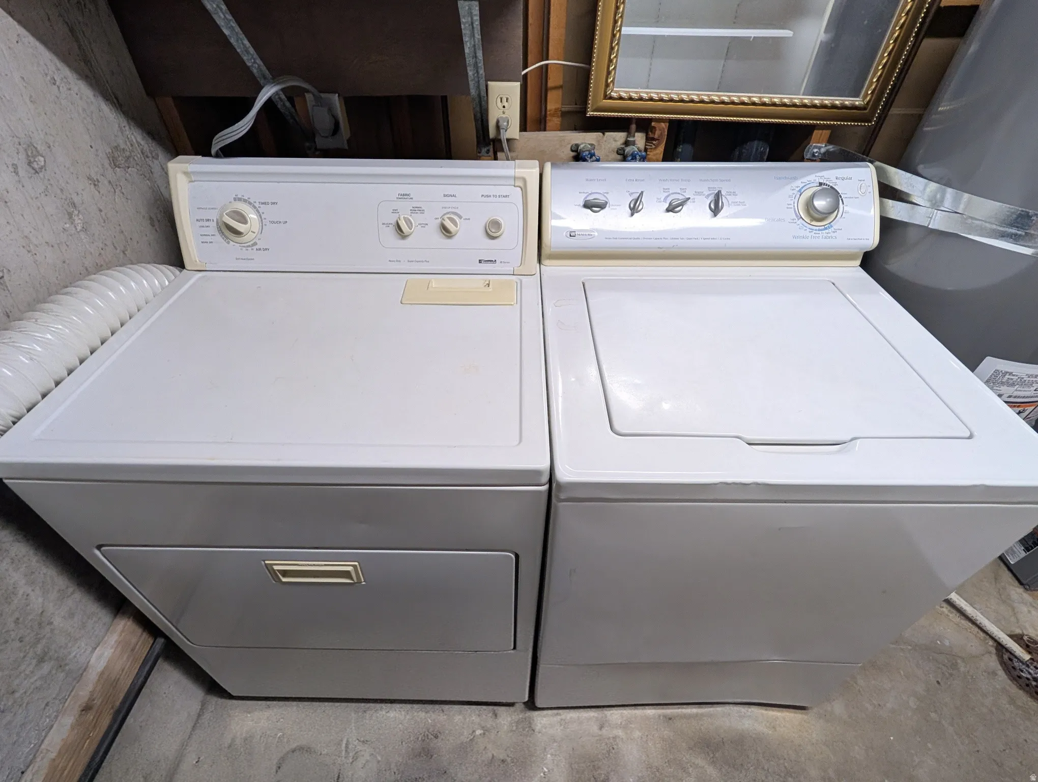 White laundry appliances with top-mounted controls and a dryer vent