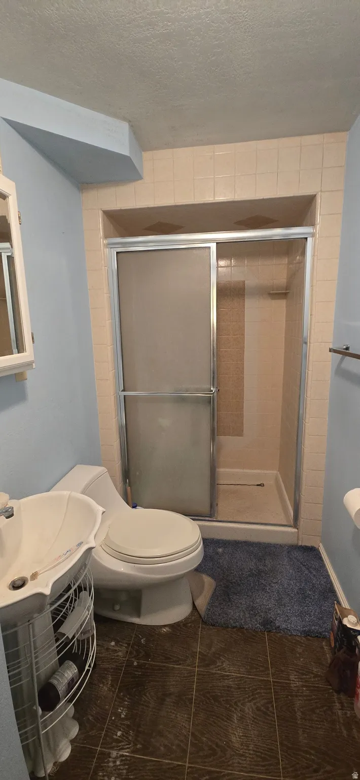 Bathroom 1 with a stall shower and a textured ceiling