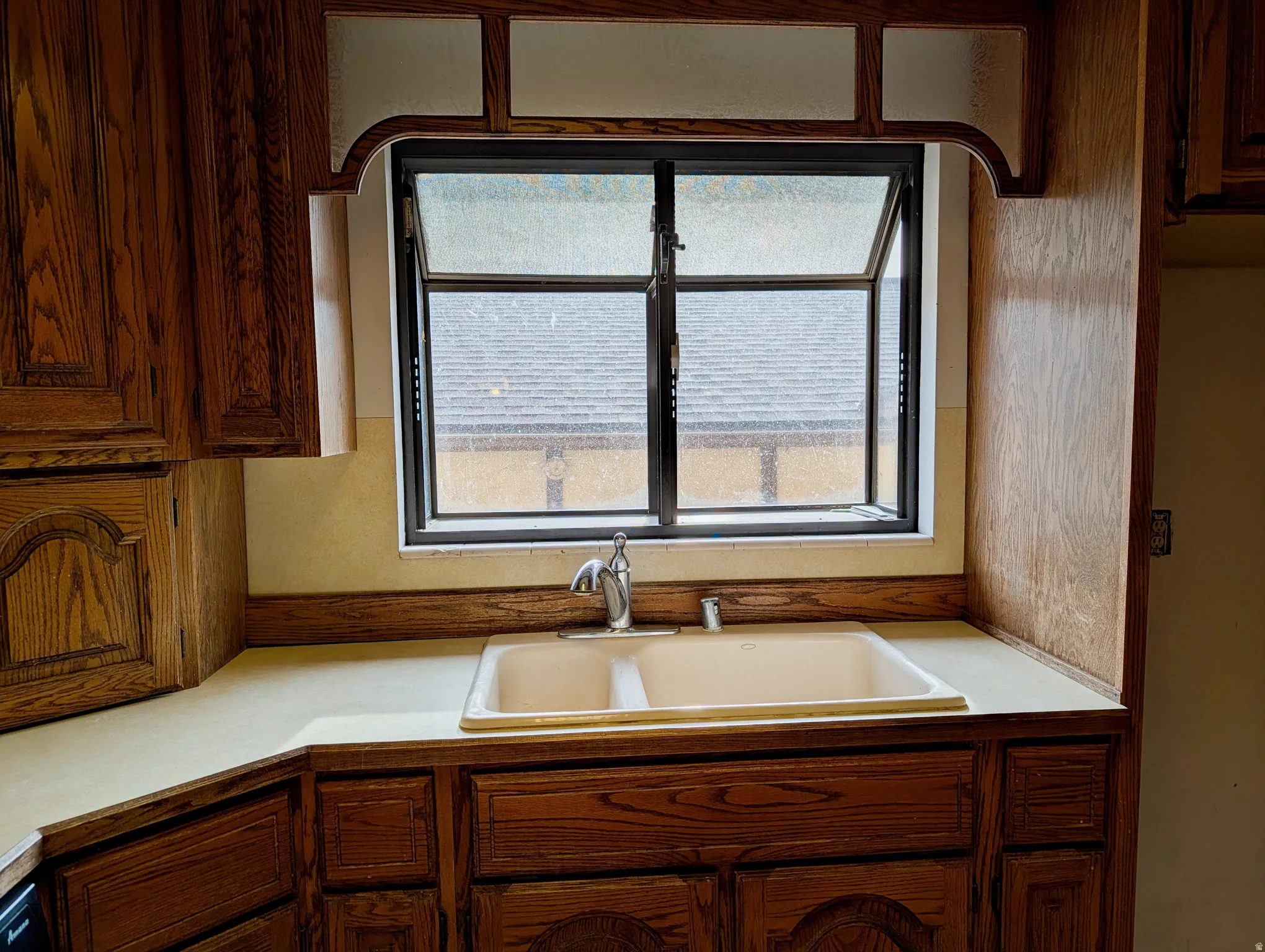Kitchen featuring light countertops and brown cabinetry