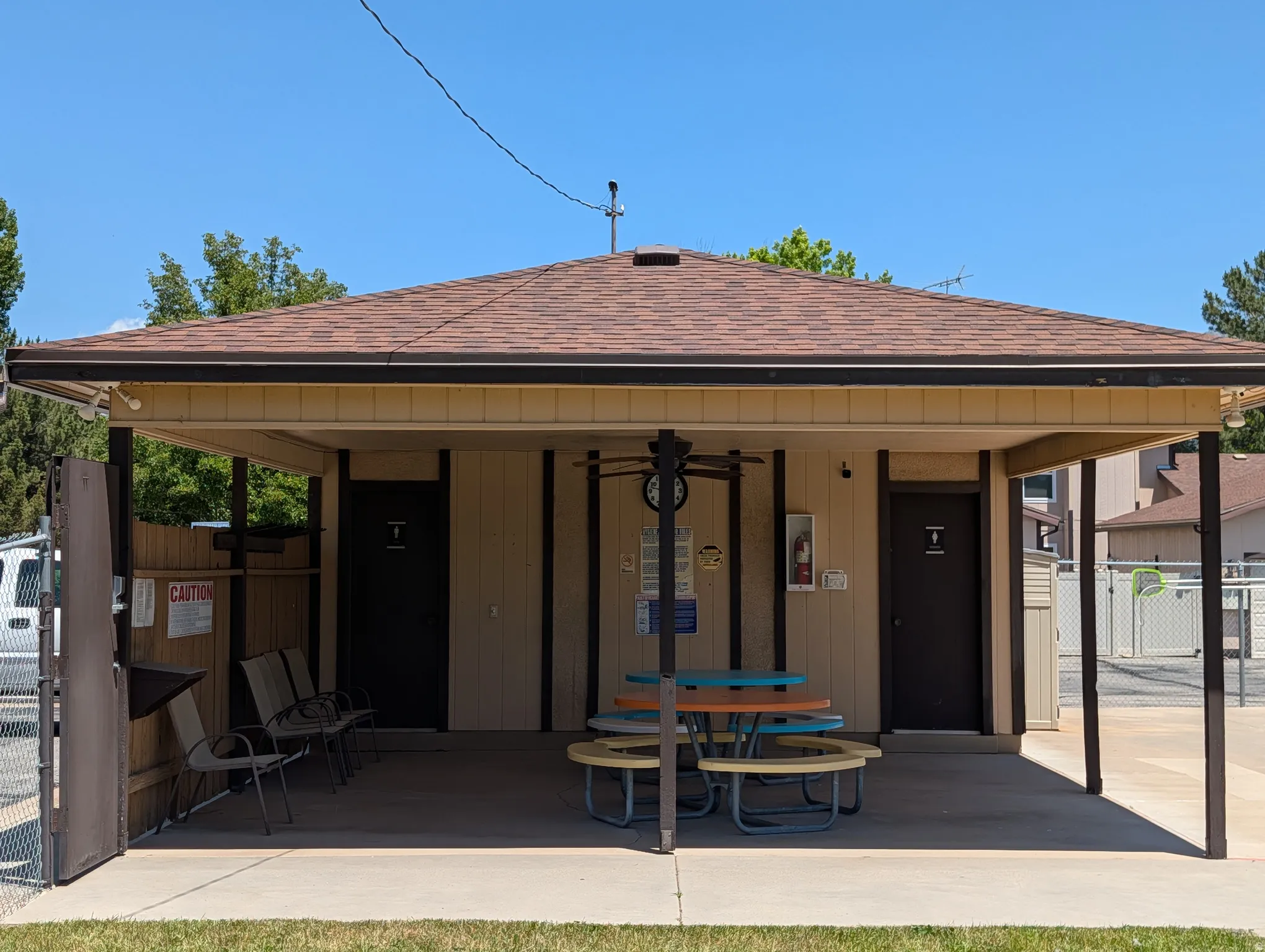 Covered patio structure featuring a shingle roof, beige siding, and dark trim