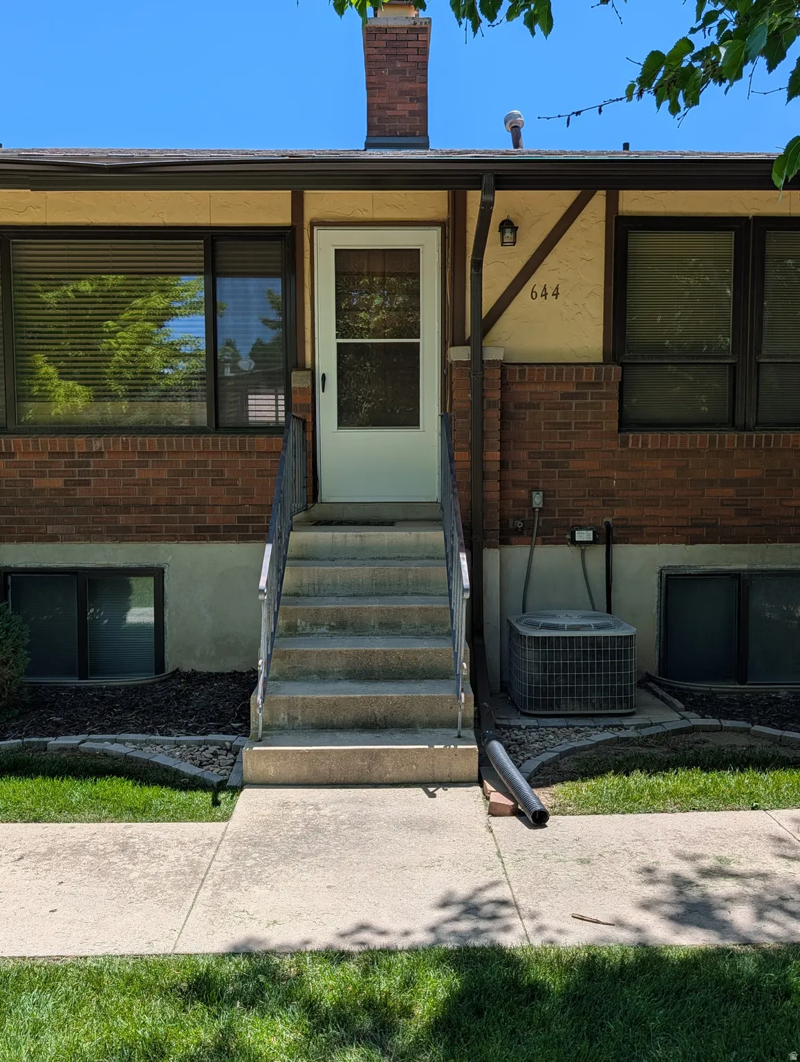 Brick facade with stucco accents and a prominent white entry door