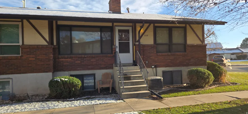 View of front of property with brick siding and a chimney