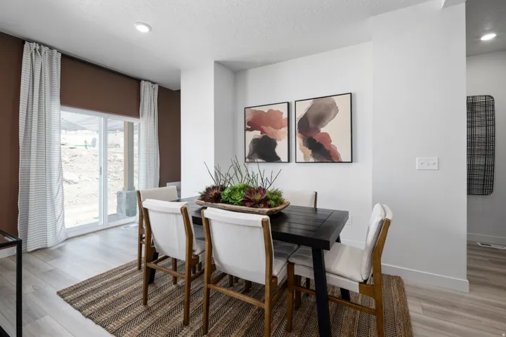 Dining area with light wood-type flooring, a textured ceiling, and recessed lighting