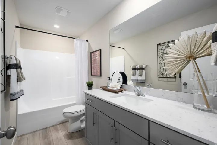 Full bathroom with shower / tub combo, vanity, and light wood-style flooring