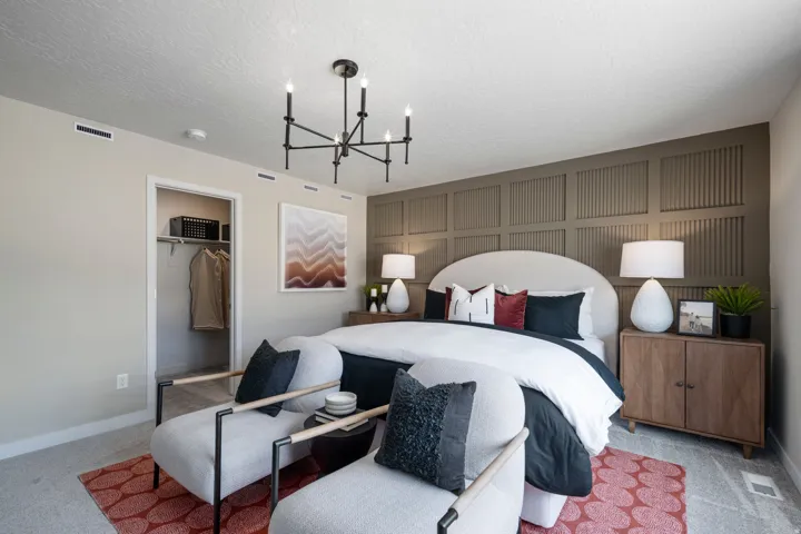 Carpeted bedroom with a chandelier and a textured ceiling
