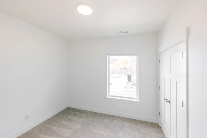 Neutral-toned carpeting complements the white walls and trim throughout this room