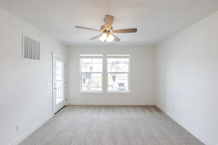 Neutral-toned carpeting complements the white walls and trim throughout this space