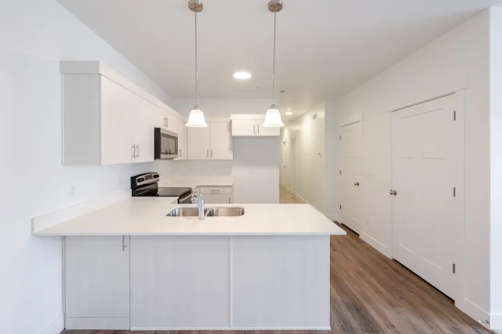 Modern kitchen featuring white cabinetry, light-toned countertops, and stainless steel appliances