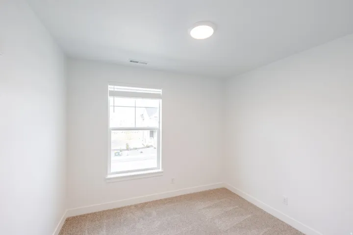 Bright room featuring a single window, recessed lighting, neutral carpet flooring, and white baseboards
