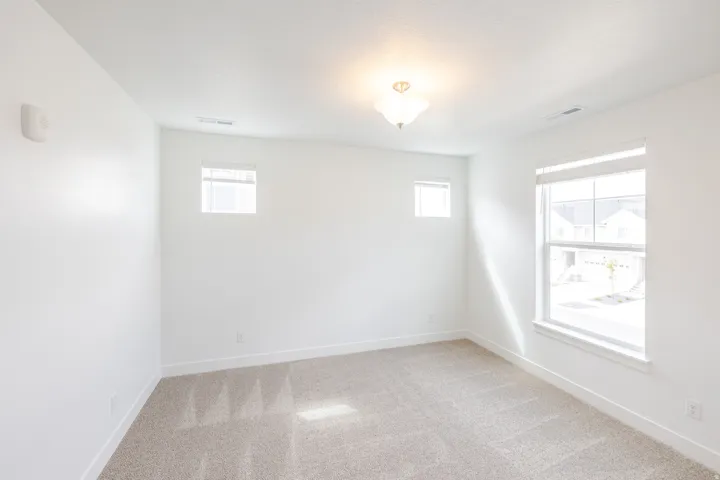Bright room featuring neutral carpeting and white baseboards