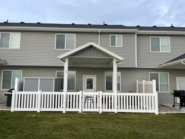 Back of house featuring a patio, vinyl fencing and 6x6 shed