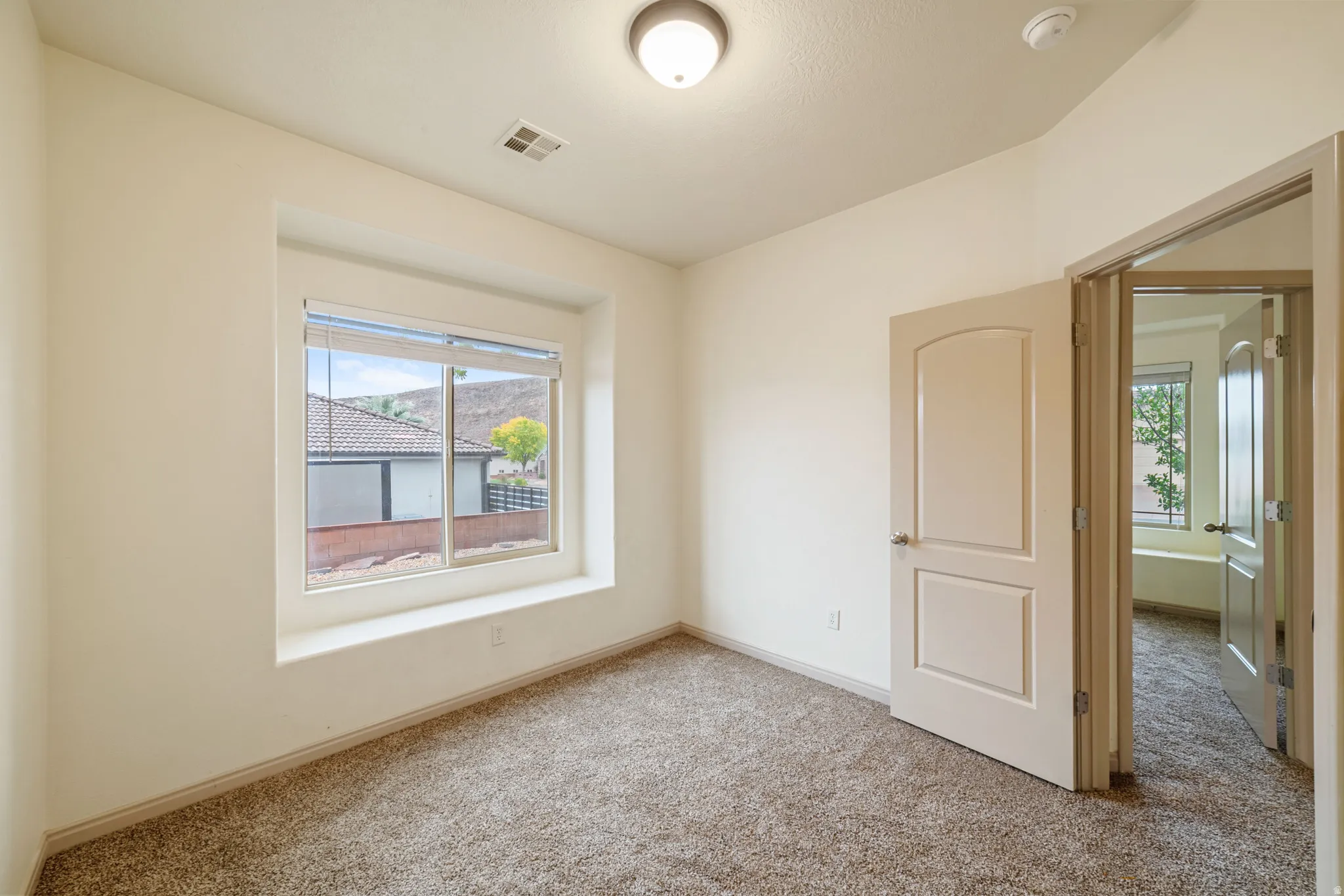 Spare room with carpet and a smoke detector