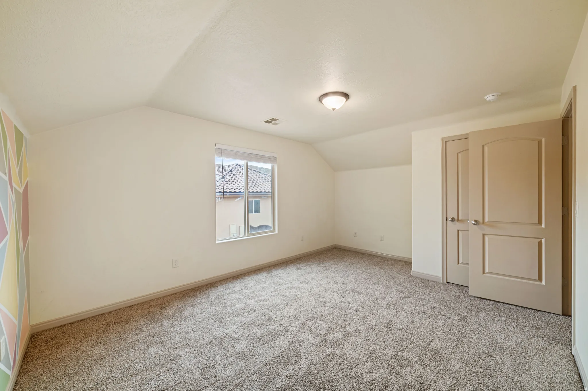 Additional living space with lofted ceiling and carpet floors