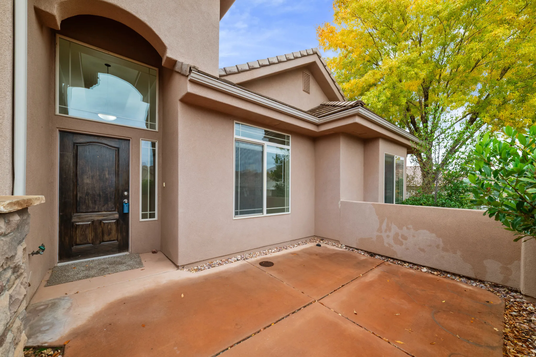 View of exterior entry featuring stucco siding, a patio, and a tiled roof