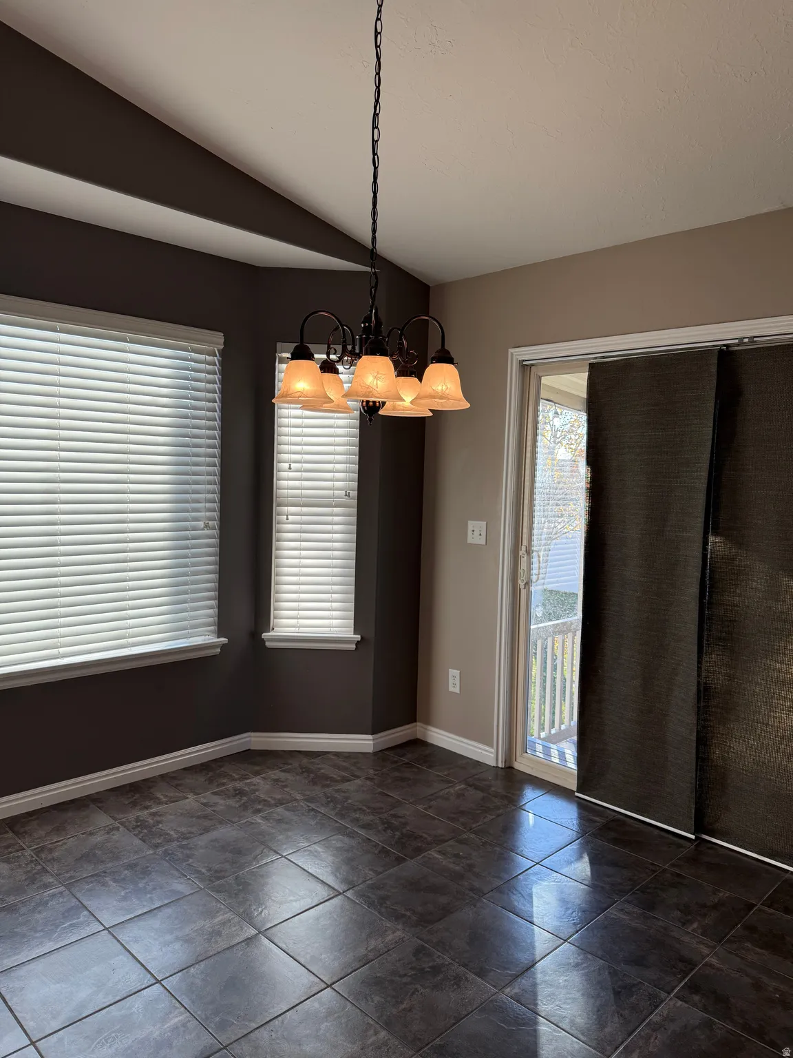 Unfurnished dining area with vaulted ceiling and a chandelier
