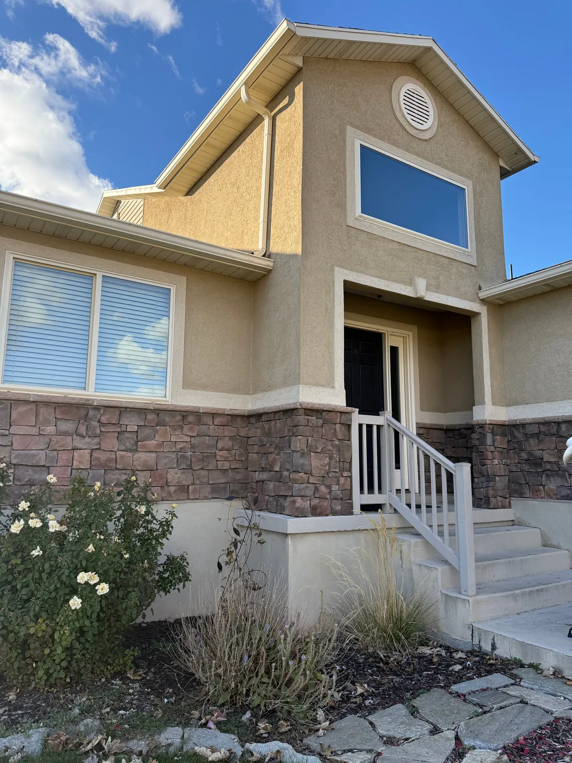 View of front of property featuring stone siding and stucco siding