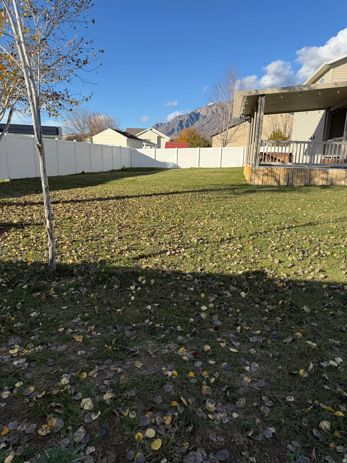 Fenced backyard featuring a deck with mountain view