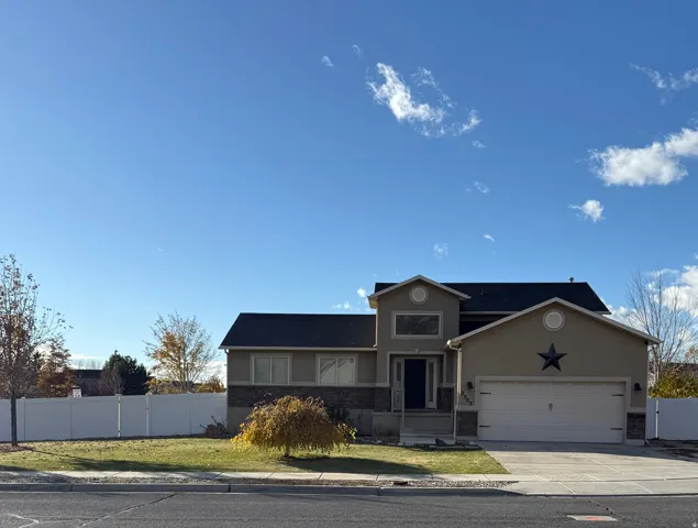 View of front of property featuring stucco siding, an attached garage, concrete driveway, and stone siding