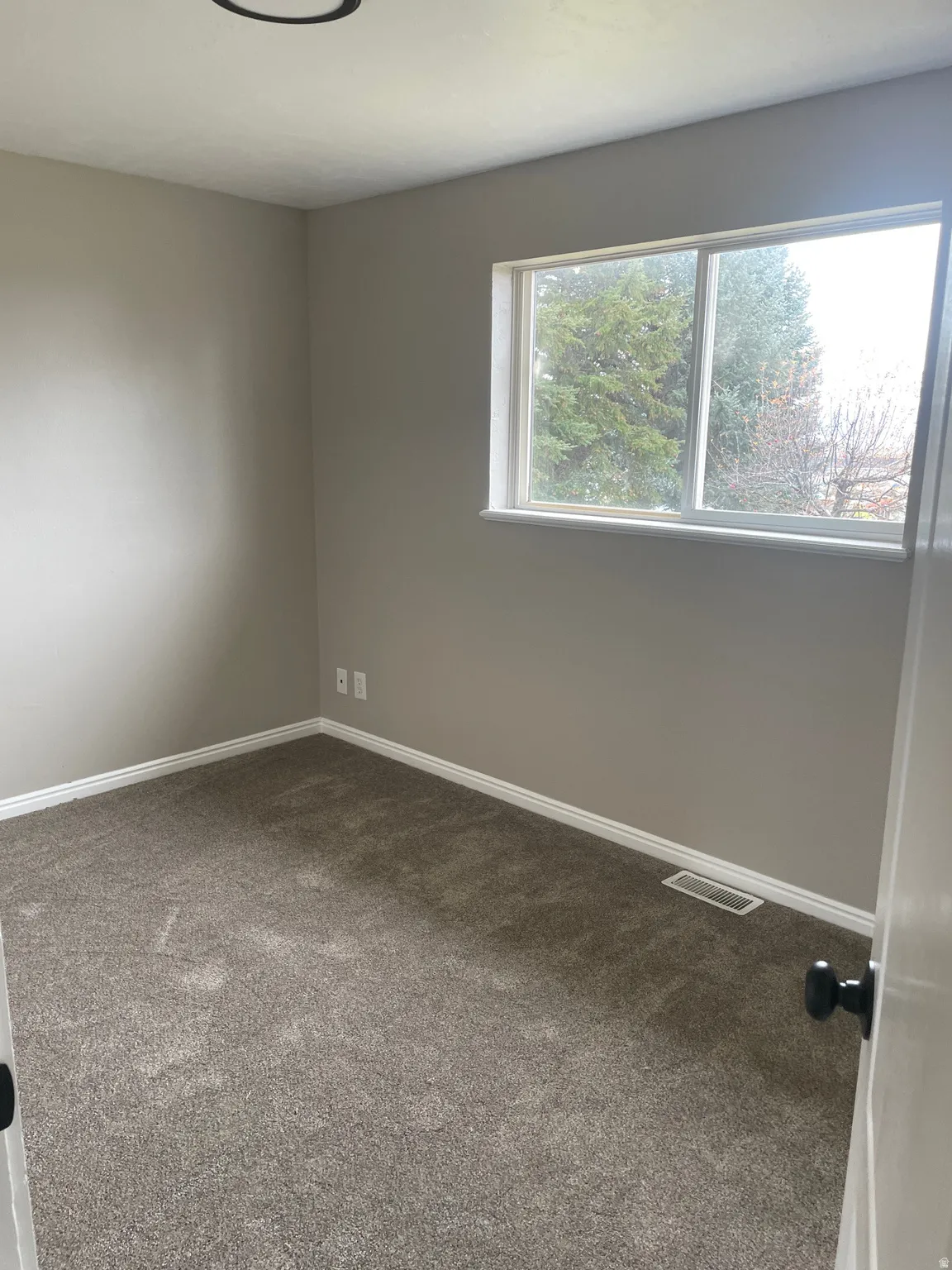 Carpeted empty room featuring baseboards