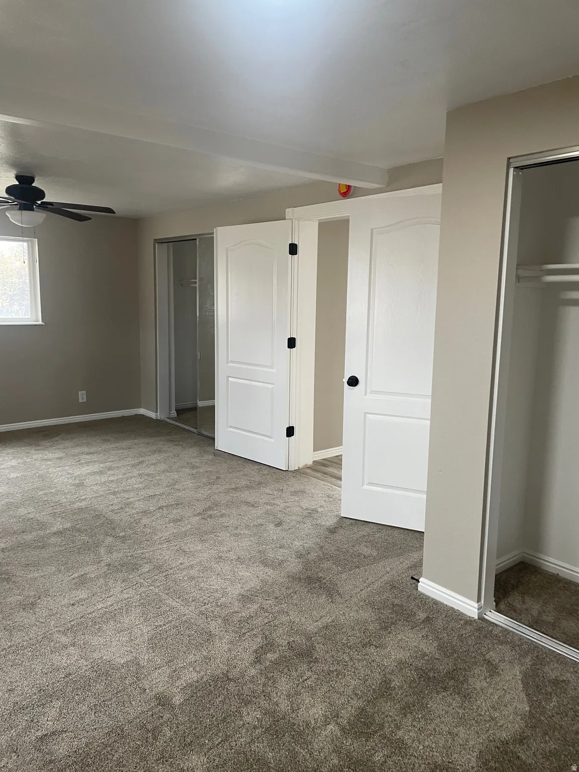 Unfurnished bedroom with carpet floors, a closet, and a ceiling fan