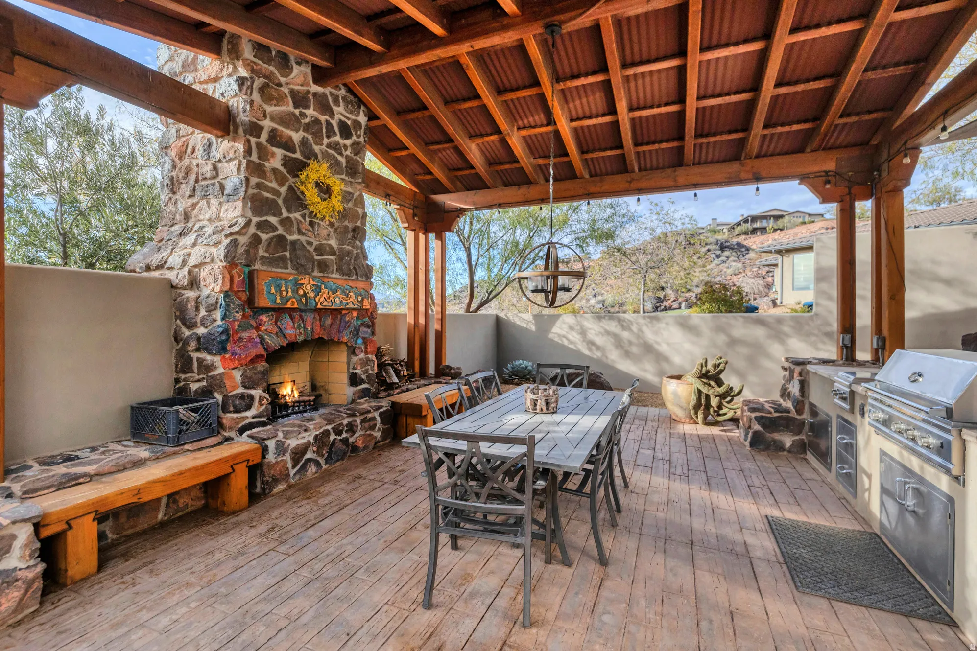 Deck featuring outdoor dining space, exterior kitchen, and an outdoor stone fireplace