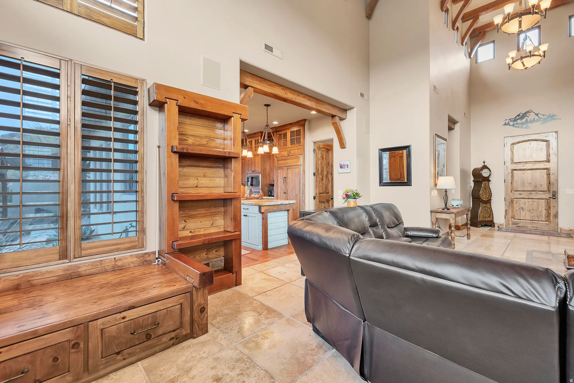 Living room with a chandelier, a towering ceiling, and light tile patterned flooring