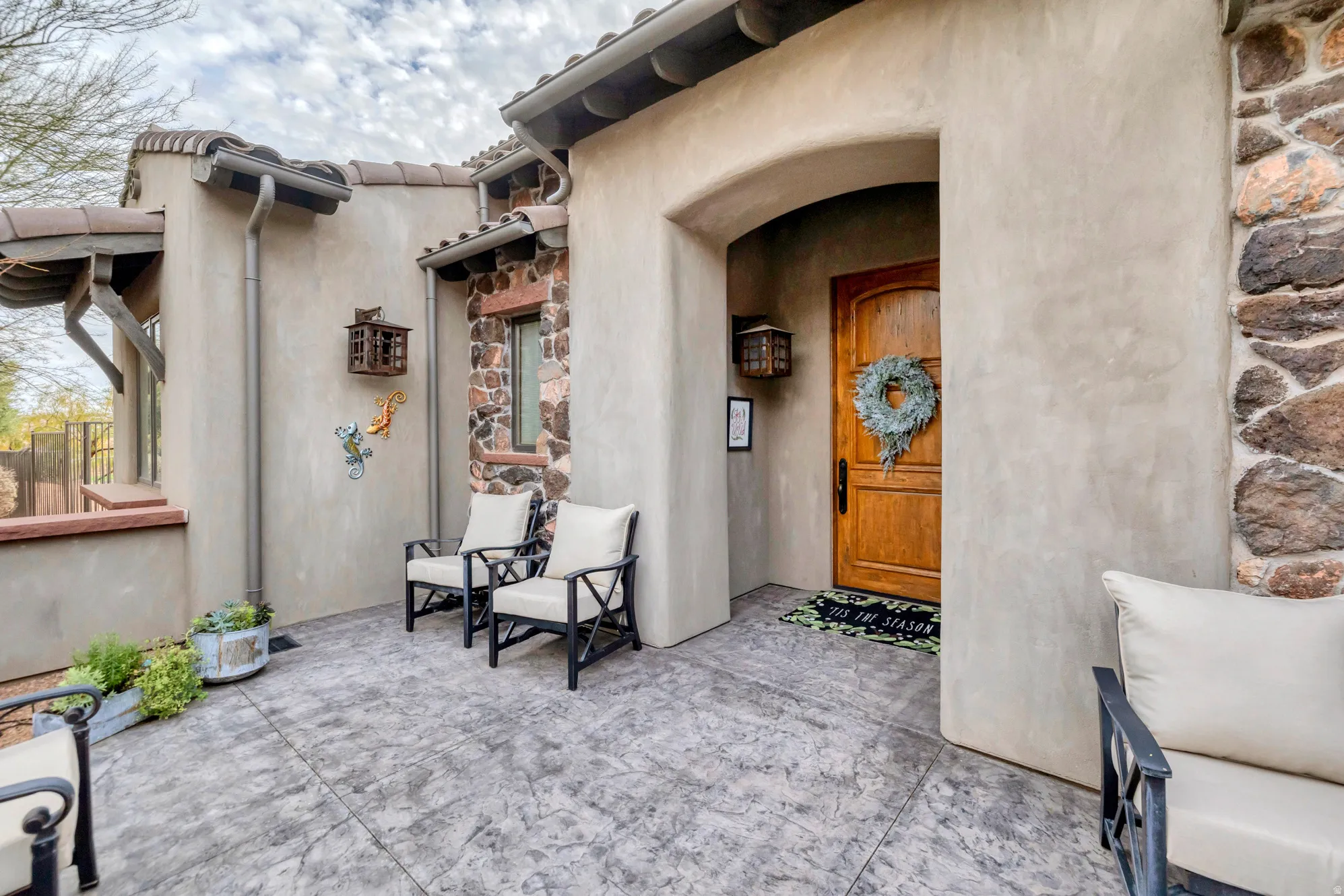 Entrance to property with stone siding and stucco siding
