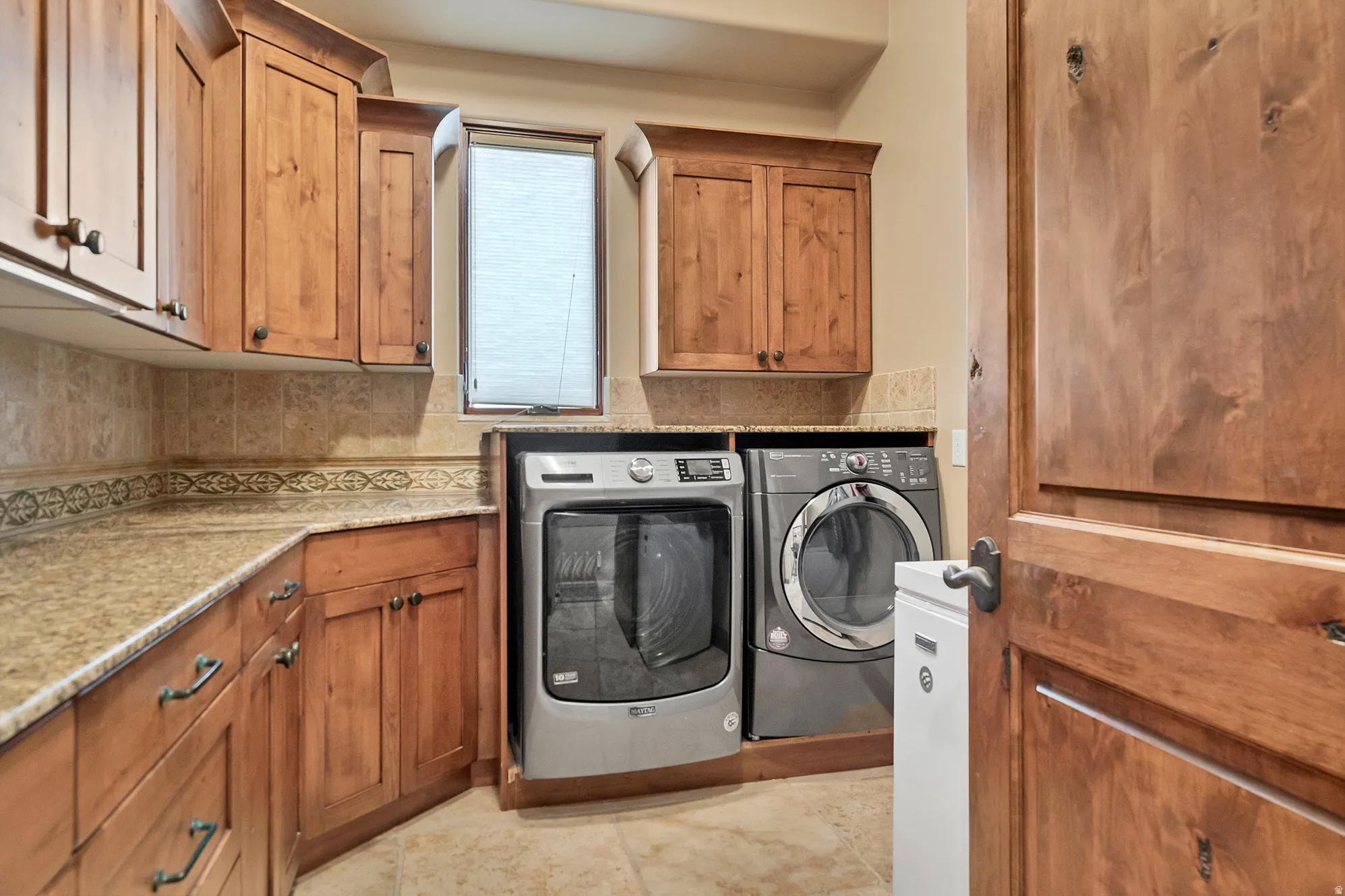 Laundry area featuring washing machine and clothes dryer and cabinet space