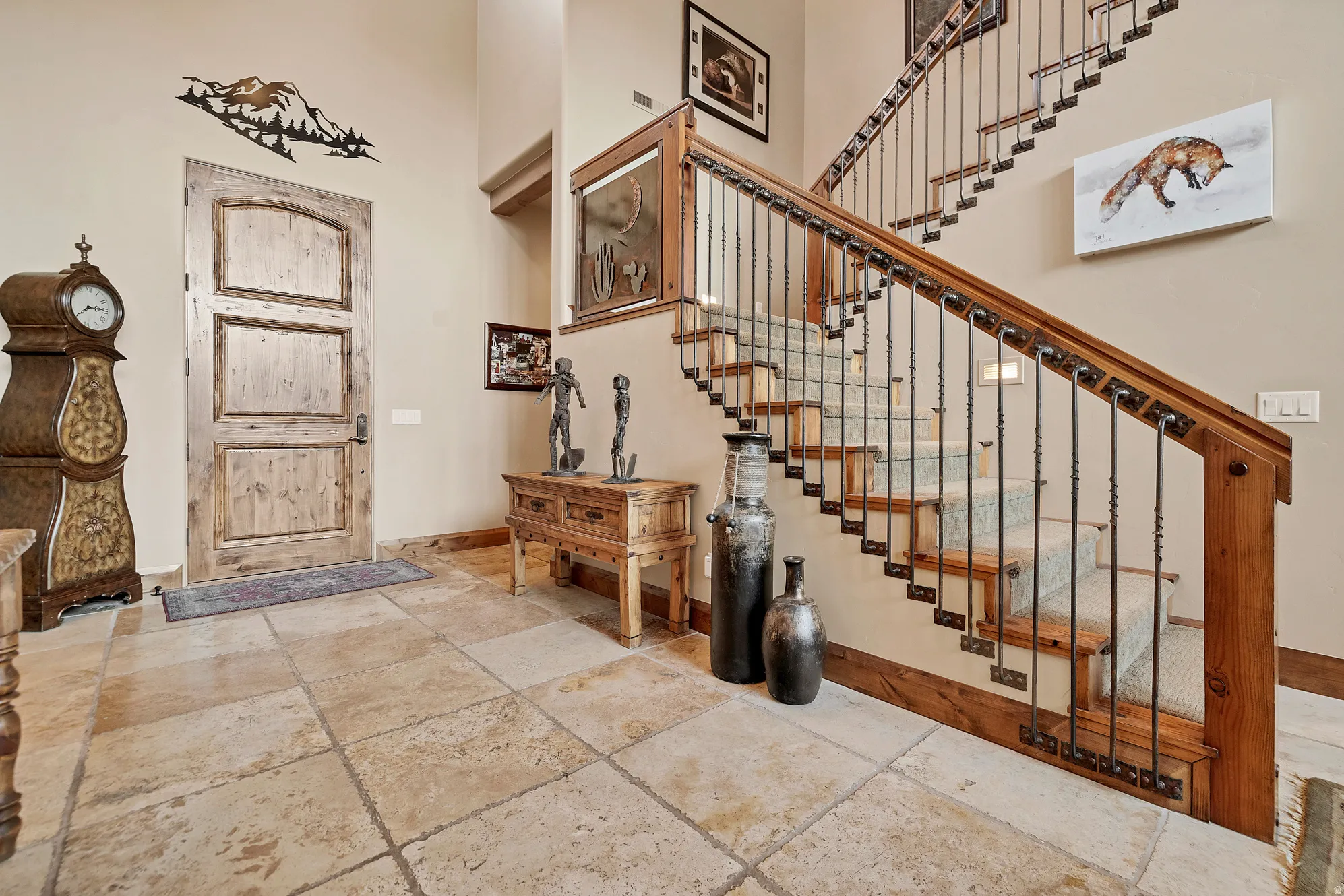 Entrance foyer featuring stone tile floors and a towering ceiling