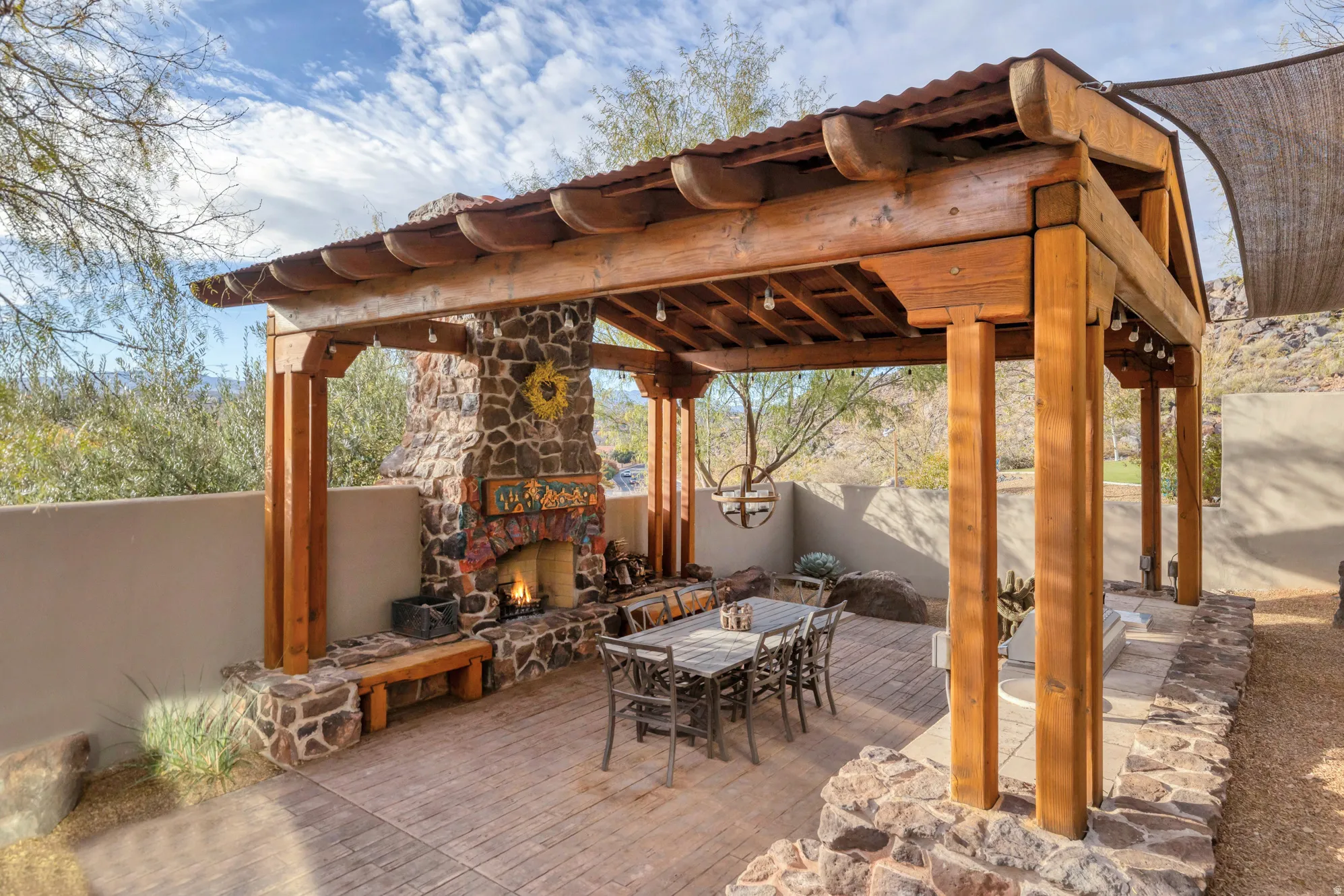 Fenced backyard featuring an outdoor stone fireplace, outdoor dining space, and a patio area