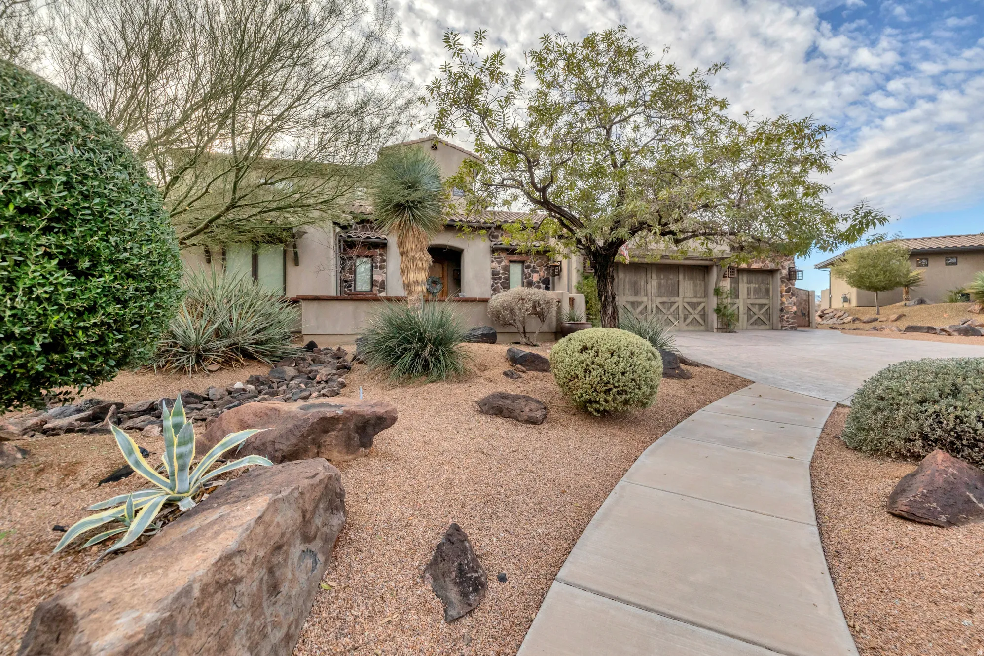 View of front of home featuring driveway, stucco siding, and a garage