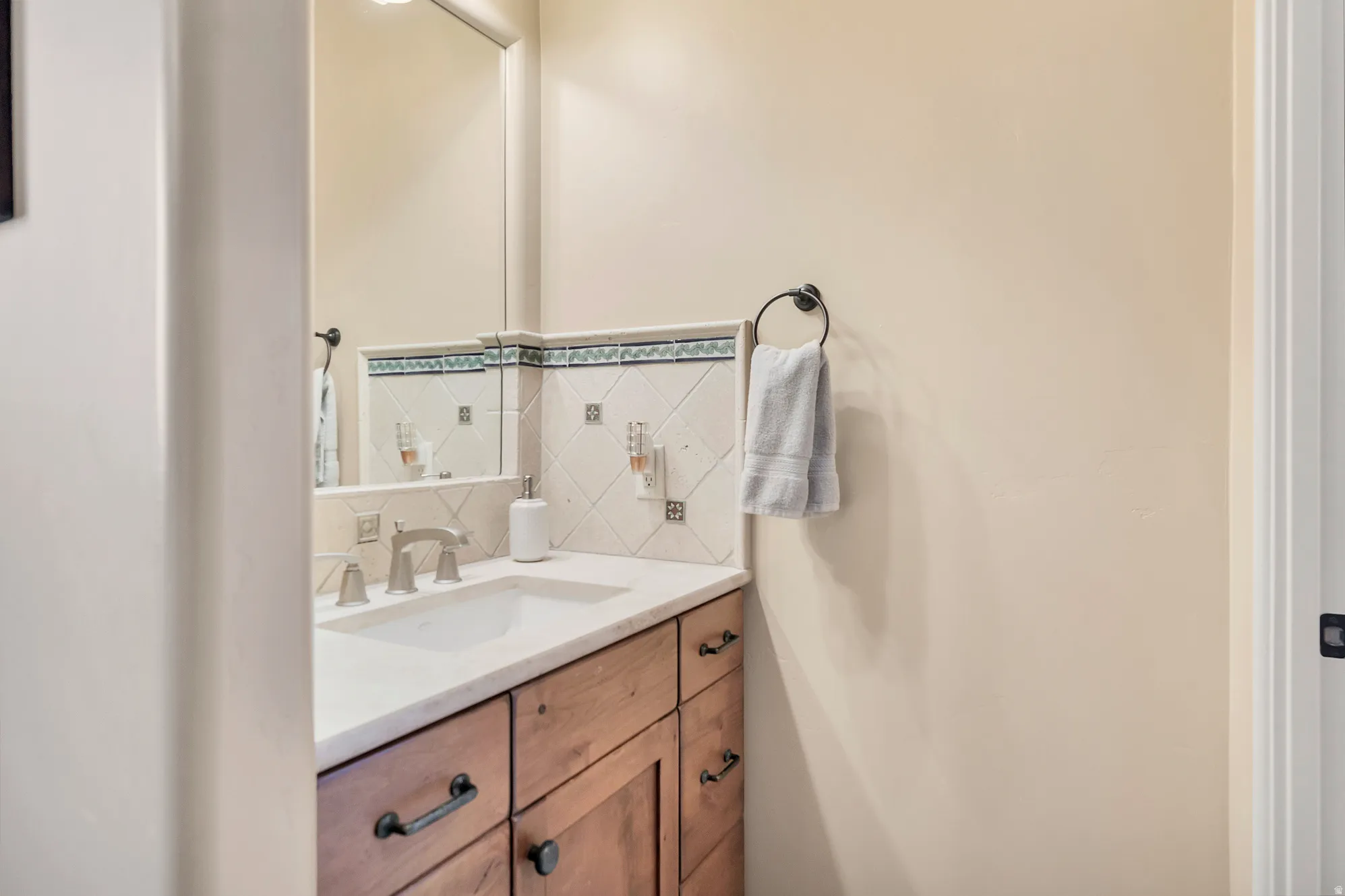 Half bathroom with decorative backsplash and vanity